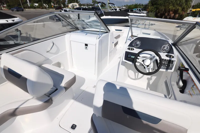 Slide: The Image of 2026 Hurricane SunDeck 235 OB boat with open storage compartment and ladder. - 17