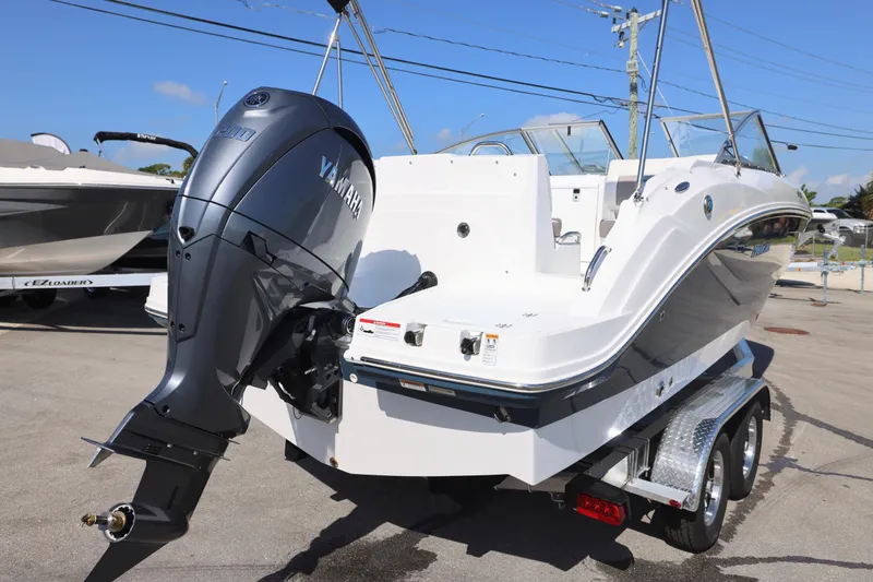 Slide: The Image of 2026 Hurricane SunDeck 235 OB boat on trailer, parked outdoors under clear sky. - 20