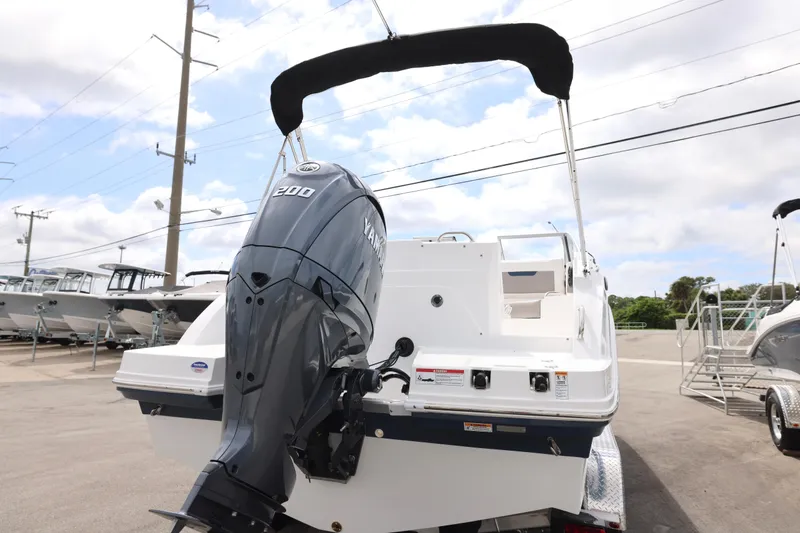 Slide: The Image of 2026 Hurricane SunDeck 235 OB boat on trailer, sleek design, blue and white finish. - 22