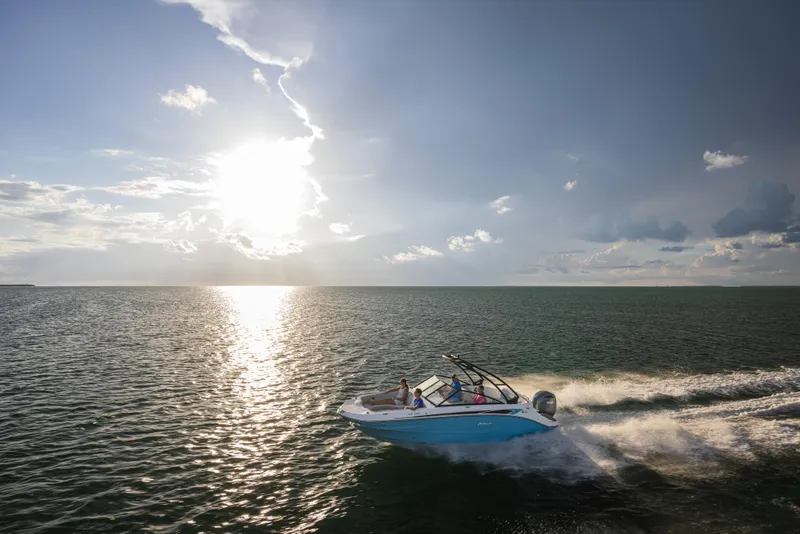 Slide: The Image of Aerial view of 2025 Hurricane SunDeck 235 OB cruising on clear green water. - 30