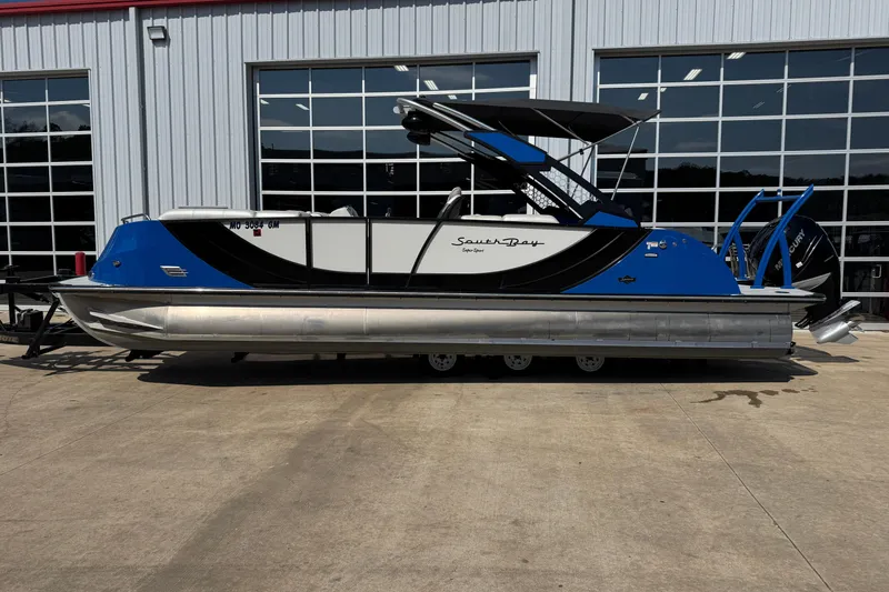 The Image of 2022 South Bay 25 Sport CR9-DC pontoon boat parked outside a building. - 1