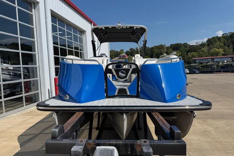 Slide: The Image of 2022 South Bay 25 Sport CR9-DC pontoon boat with blue exterior, parked outside a showroom. - 3