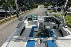 Slide: The Image of 2012 MasterCraft X25 boat with blue and white interior, parked on a street. - 5