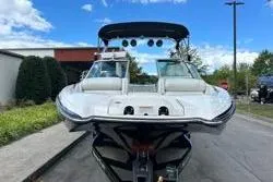 Slide: The Image of 2012 MasterCraft X25 boat with sleek design, parked outdoors under blue sky. - 6