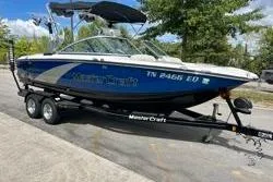 Slide: The Image of 2012 MasterCraft X25 boat on trailer, blue and white, parked outdoors. - 9