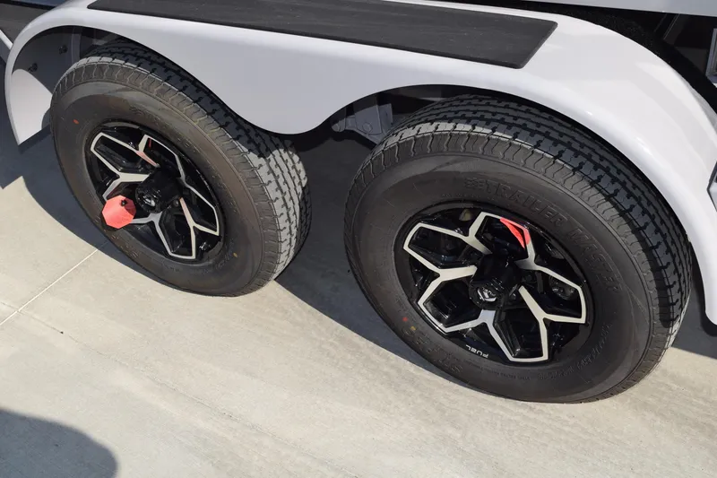 Slide: The Image of 2026 Moomba Max trailer wheels with black alloy rims on concrete surface. - 11