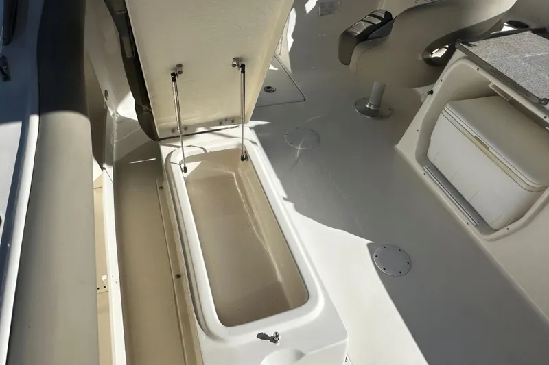Slide: The Image of 2023 Key West 239 DFS boat interior with open storage compartment and seating. - 13
