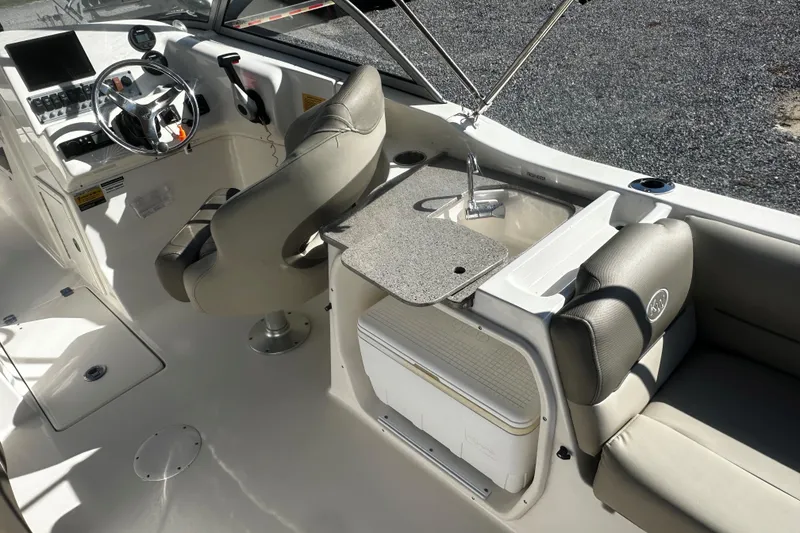 Slide: The Image of 2023 Key West 239 DFS boat interior with helm, seating, and sink area. - 6