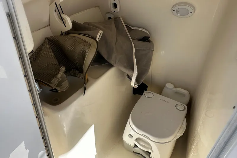 Slide: The Image of 2023 Key West 239 DFS boat interior with portable toilet and storage area. - 9
