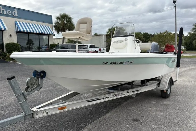 Slide: The Image of 2015 NauticStar 1910 NauticBay boat on trailer, parked outside a building. - 8