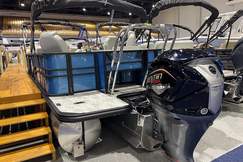 Slide: The Image of 2026 Sylvan Mirage X X3 Party Fish pontoon boat with Yamaha outboard motor displayed indoors. - 2