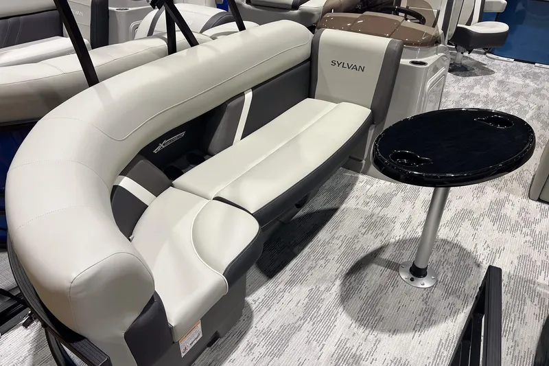 Slide: The Image of 2026 Sylvan Mirage X X3 Party Fish boat interior with curved seating and table. - 7