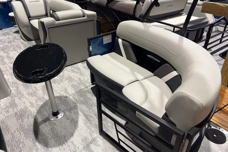 Slide: The Image of 2026 Sylvan Mirage X X3 Party Fish boat interior with plush seating and table. - 8