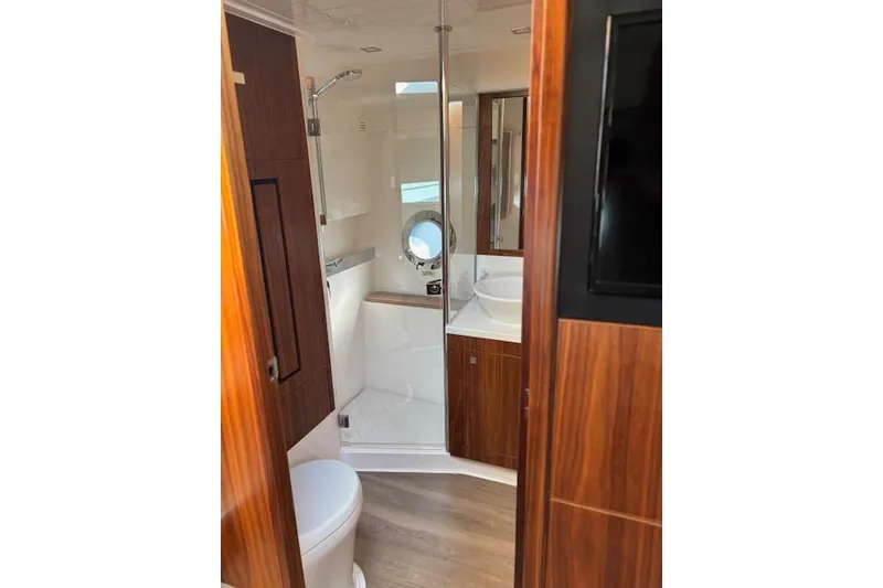 Slide: The Image of Luxurious bathroom interior of 2020 Riviera 4800 Sport Yacht with wood accents and modern fixtures. - 15