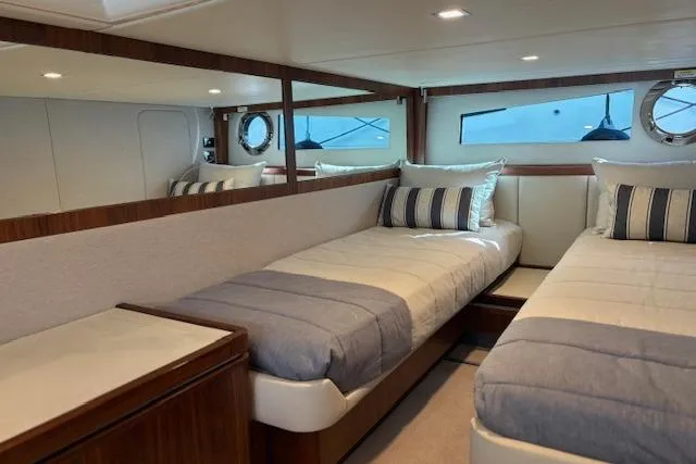Slide: The Image of Interior of 2020 Riviera 4800 Sport Yacht with twin beds and elegant decor. - 16