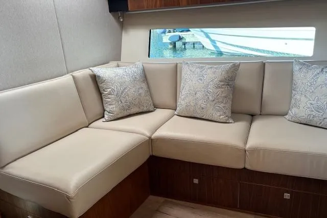 Slide: The Image of Luxurious interior of 2020 Riviera 4800 Sport Yacht with elegant beige seating and cushions. - 21