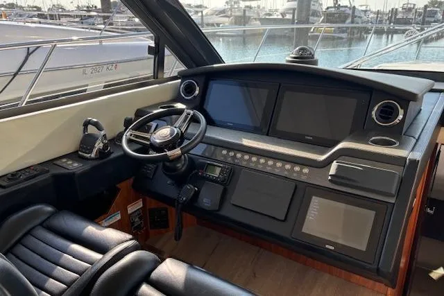 Slide: The Image of 2020 Riviera 4800 Sport Yacht helm with modern navigation displays and luxurious seating. - 22