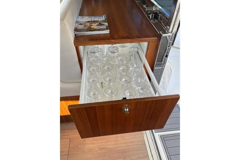 Slide: The Image of Wooden drawer with glassware in a 2020 Riviera 4800 Sport Yacht interior. - 23