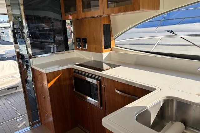 Slide: The Image of Modern kitchen interior of 2020 Riviera 4800 Sport Yacht with sleek wood cabinetry. - 25