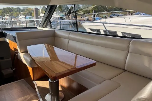 Slide: The Image of Interior of 2020 Riviera 4800 Sport Yacht with elegant seating and wooden table. - 27
