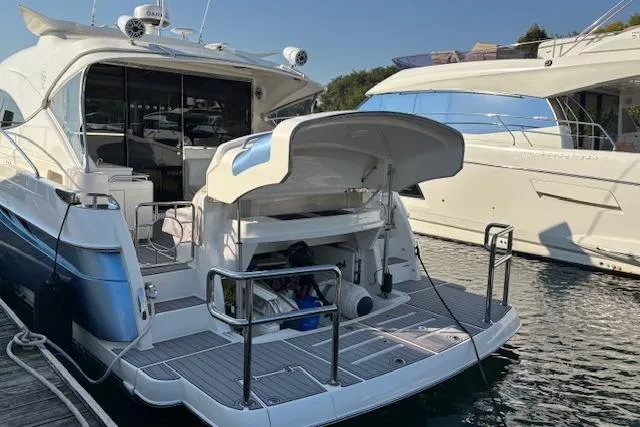 Slide: The Image of 2020 Riviera 4800 Sport Yacht docked, showcasing sleek design and spacious deck. - 30