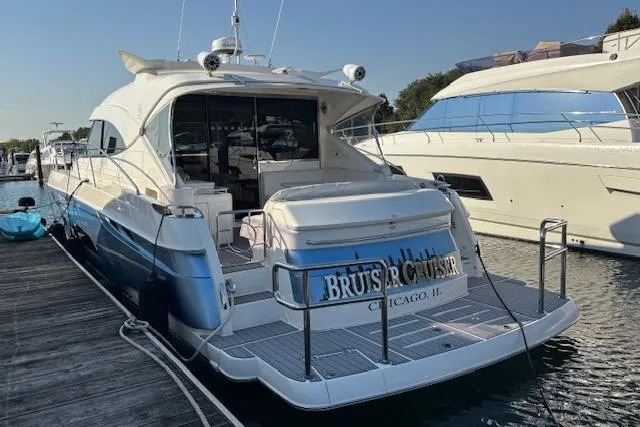 Slide: The Image of 2020 Riviera 4800 Sport Yacht docked, rear view, in a marina setting. - 33