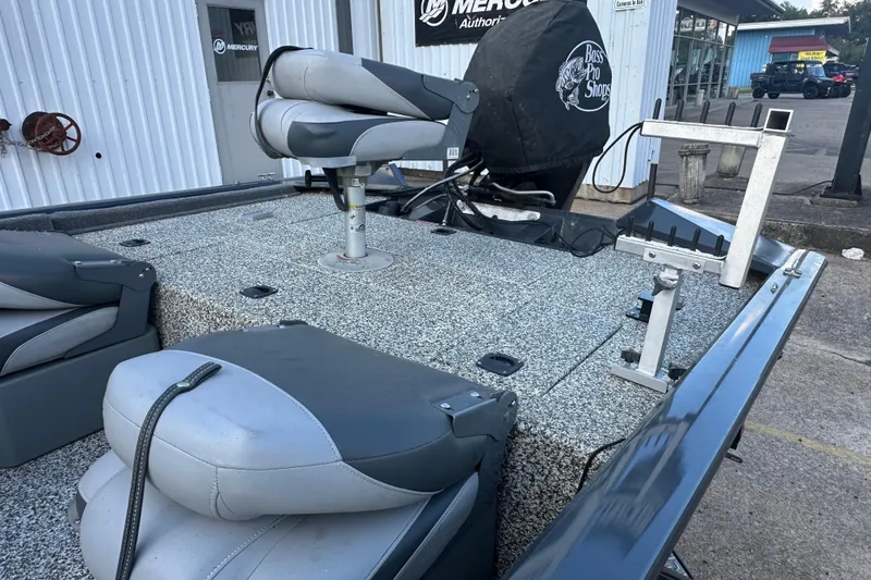 Slide: The Image of 2014 Tracker Pro Team 175 TF fishing boat with seating and equipment, parked outside a building. - 15