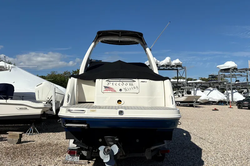 Slide: The Image of 2007 Sea Ray 260 Sundancer boat in storage yard under clear blue sky. - 1