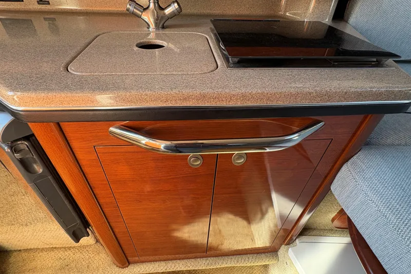 Slide: The Image of 2007 Sea Ray 260 Sundancer galley with microwave, sink, and stove. - 13