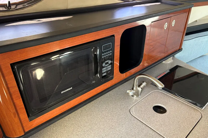 Slide: The Image of 2007 Sea Ray 260 Sundancer cabin with wood finish and compact refrigerator. - 15