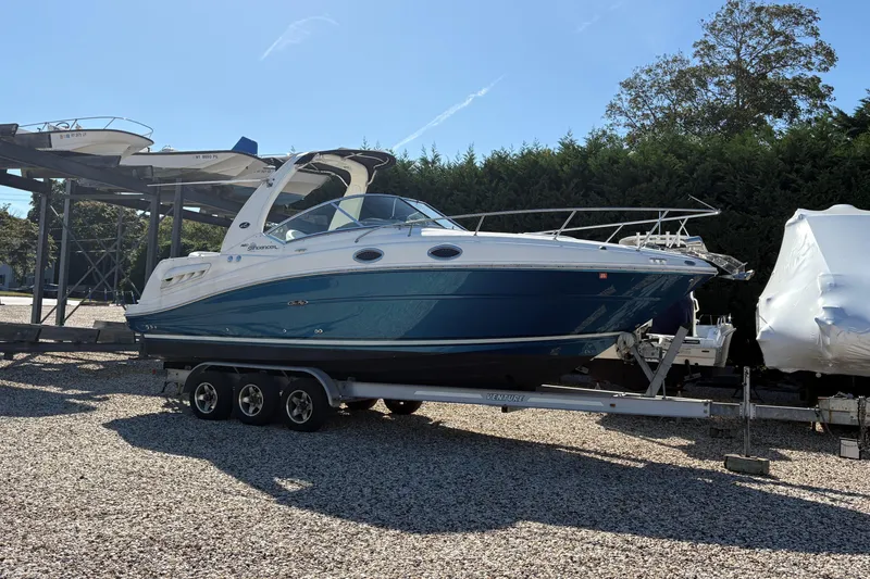 Slide: The Image of 2007 Sea Ray 260 Sundancer boat on trailer, parked outdoors under clear blue sky. - 22