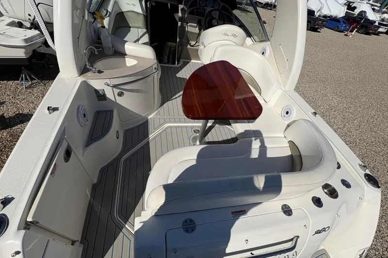 Slide: The Image of 2007 Sea Ray 260 Sundancer boat interior with seating and wooden table. - 6