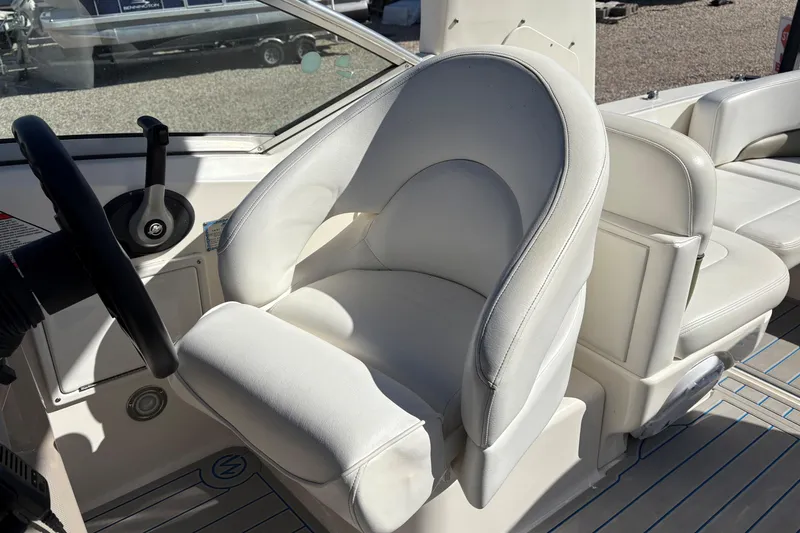 Slide: The Image of Captain's seat of 2007 Sea Ray 260 Sundancer boat, featuring white upholstery and steering wheel. - 8