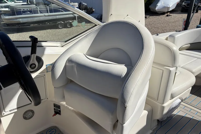 Slide: The Image of 2007 Sea Ray 260 Sundancer cockpit with white leather seating and steering wheel. - 9