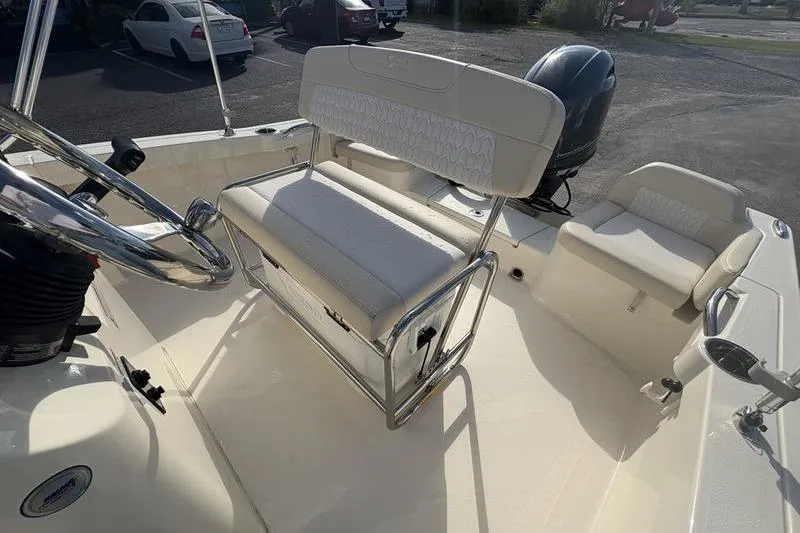 Slide: The Image of 2026 Scout 188 Sportfish boat interior with seating and steering wheel, parked outdoors. - 13