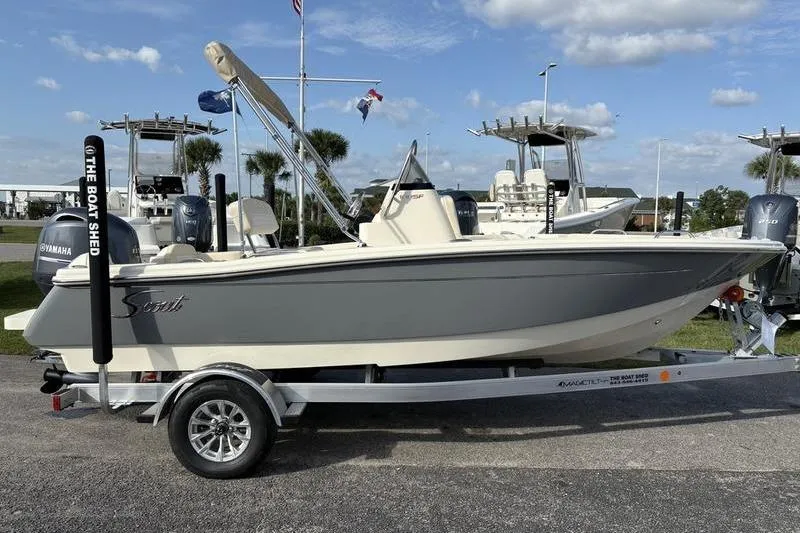 Slide: The Image of 2026 Scout 188 Sportfish boat on trailer, displayed outdoors under a clear sky. - 7