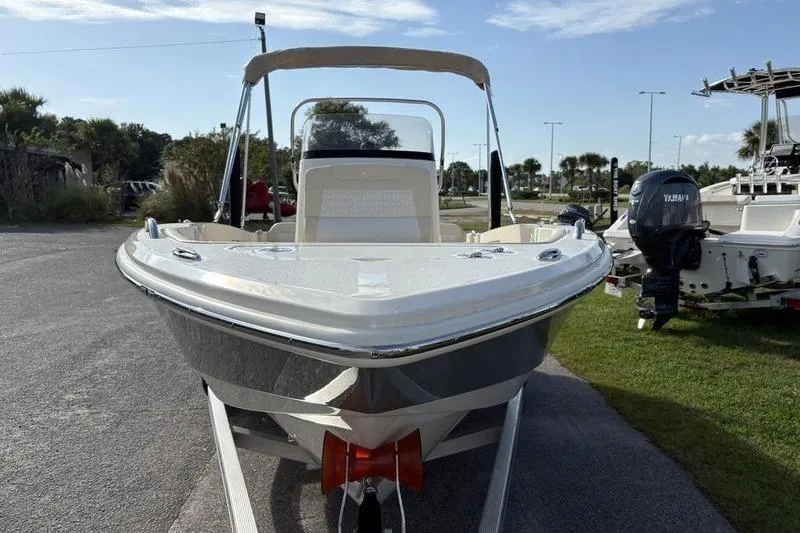 Slide: The Image of 2026 Scout 188 Sportfish boat on trailer, parked outdoors under clear sky. - 8