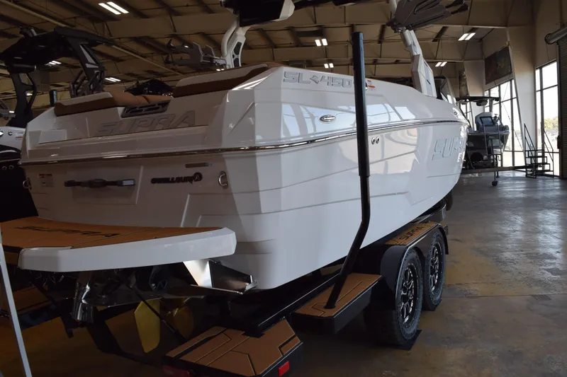 Slide: The Image of 2025 Supra SL boat in showroom, rear view with trailer and swim platform. - 3