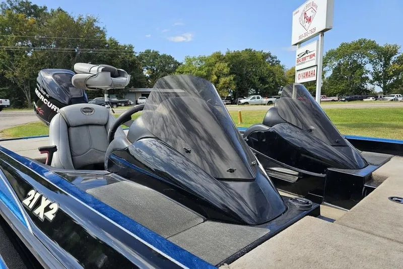 Slide: The Image of 2007 Triton 21 X-2 DEMO boat with dual consoles and Mercury engine, parked outdoors. - 10