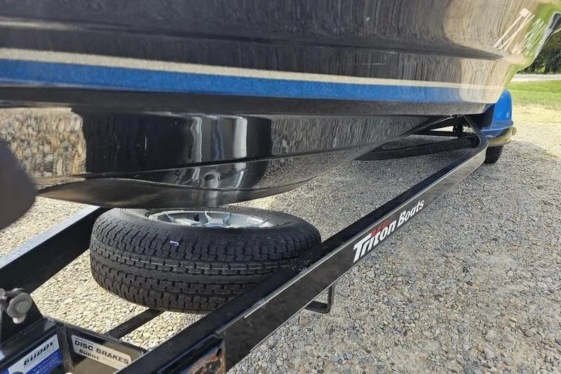 Slide: The Image of 2007 Triton 21 X-2 DEMO boat on trailer with visible tire and disc brakes. - 13