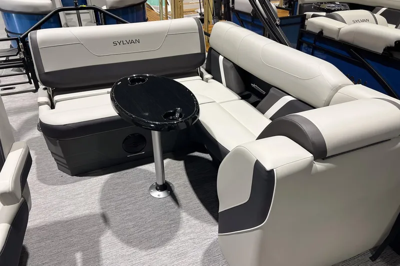 Slide: The Image of 2025 Sylvan Mirage X X3 CLZ boat interior with plush seating and a central table. - 11