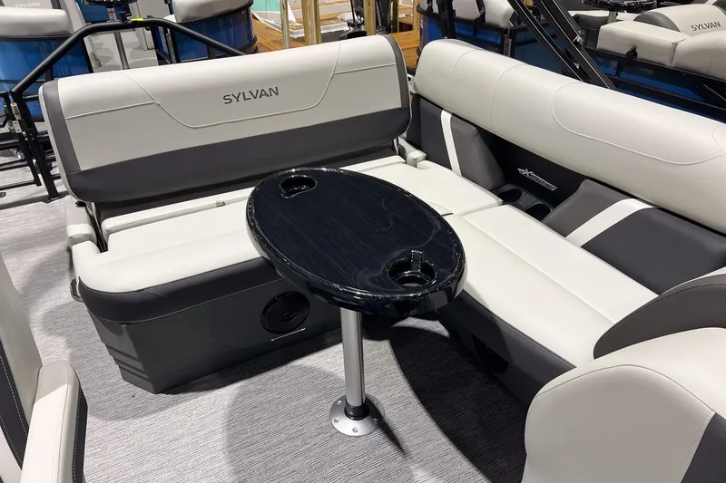 Slide: The Image of 2025 Sylvan Mirage X X3 CLZ boat interior with sleek seating and a central table. - 12