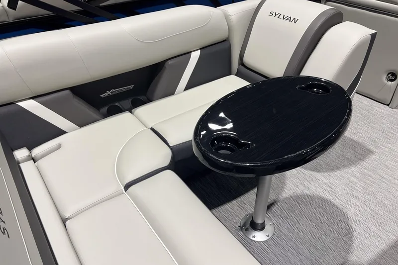 Slide: The Image of 2025 Sylvan Mirage X X3 CLZ boat interior with sleek seating and oval table. - 14
