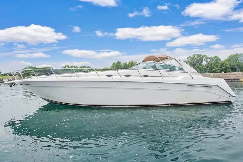 The Image of 1998 Sea Ray 500 Sundancer yacht on calm water under a blue sky. - 1