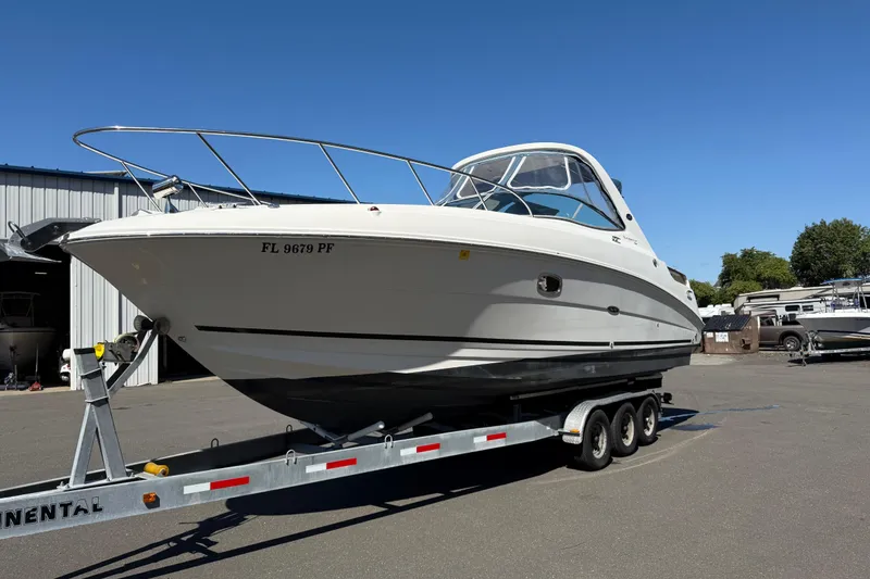 Slide: The Image of 2010 Sea Ray 310 Sundancer boat on trailer, parked outdoors under clear blue sky. - 5
