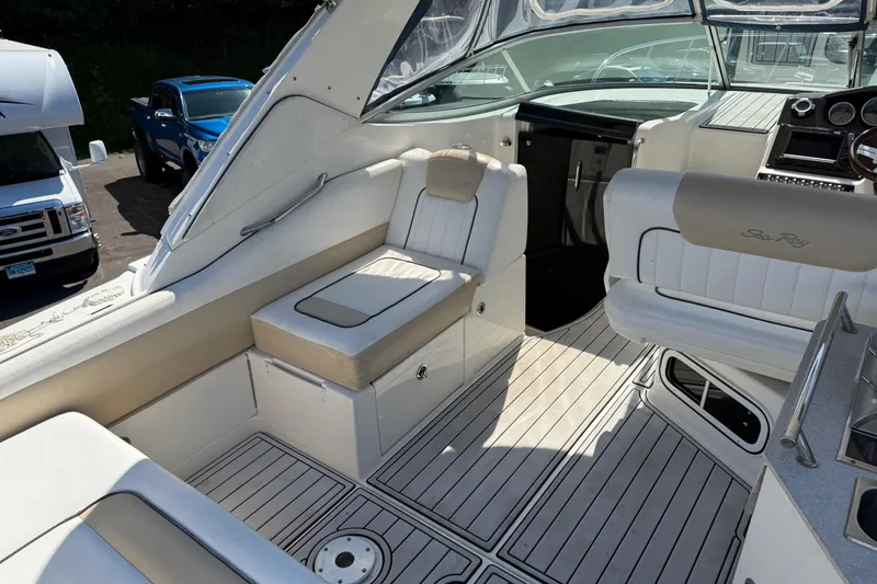 Slide: The Image of 2010 Sea Ray 310 Sundancer boat interior with white seating and dashboard. - 7