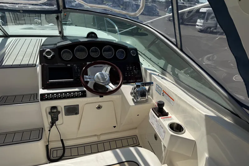 Slide: The Image of 2010 Sea Ray 310 Sundancer helm with steering wheel and control panel. - 8