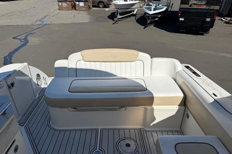 Slide: The Image of 2010 Sea Ray 310 Sundancer boat interior with cushioned seating and deck view. - 9