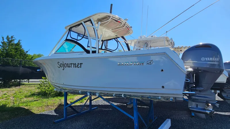 Slide: The Image of 2019 Sailfish 275 DC boat on stand, featuring Yamaha engines, clear sky background. - 1