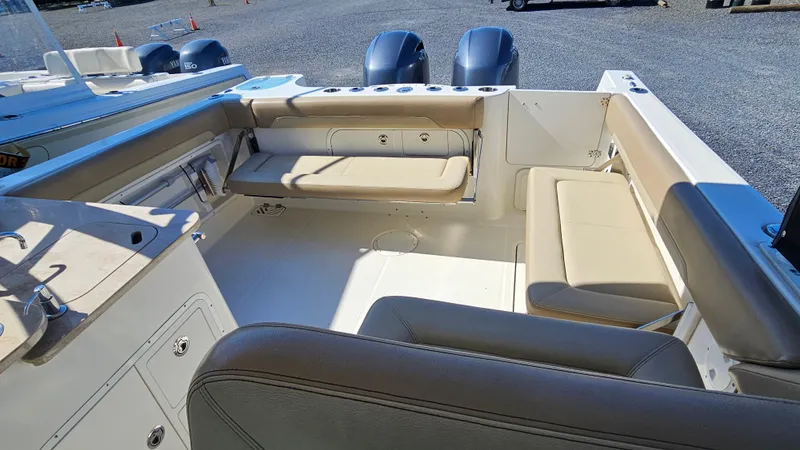 Slide: The Image of 2019 Sailfish 275 DC boat interior with beige seating and dual outboard motors. - 14